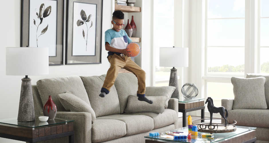 Boy jumping on sofa