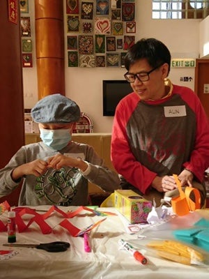 adult helping child with crafts