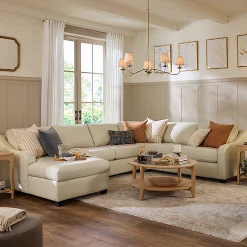 beige sectional with colorful throw pillows and blanket
