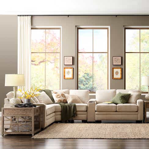 beige sectional with colorful throw pillows and blanket