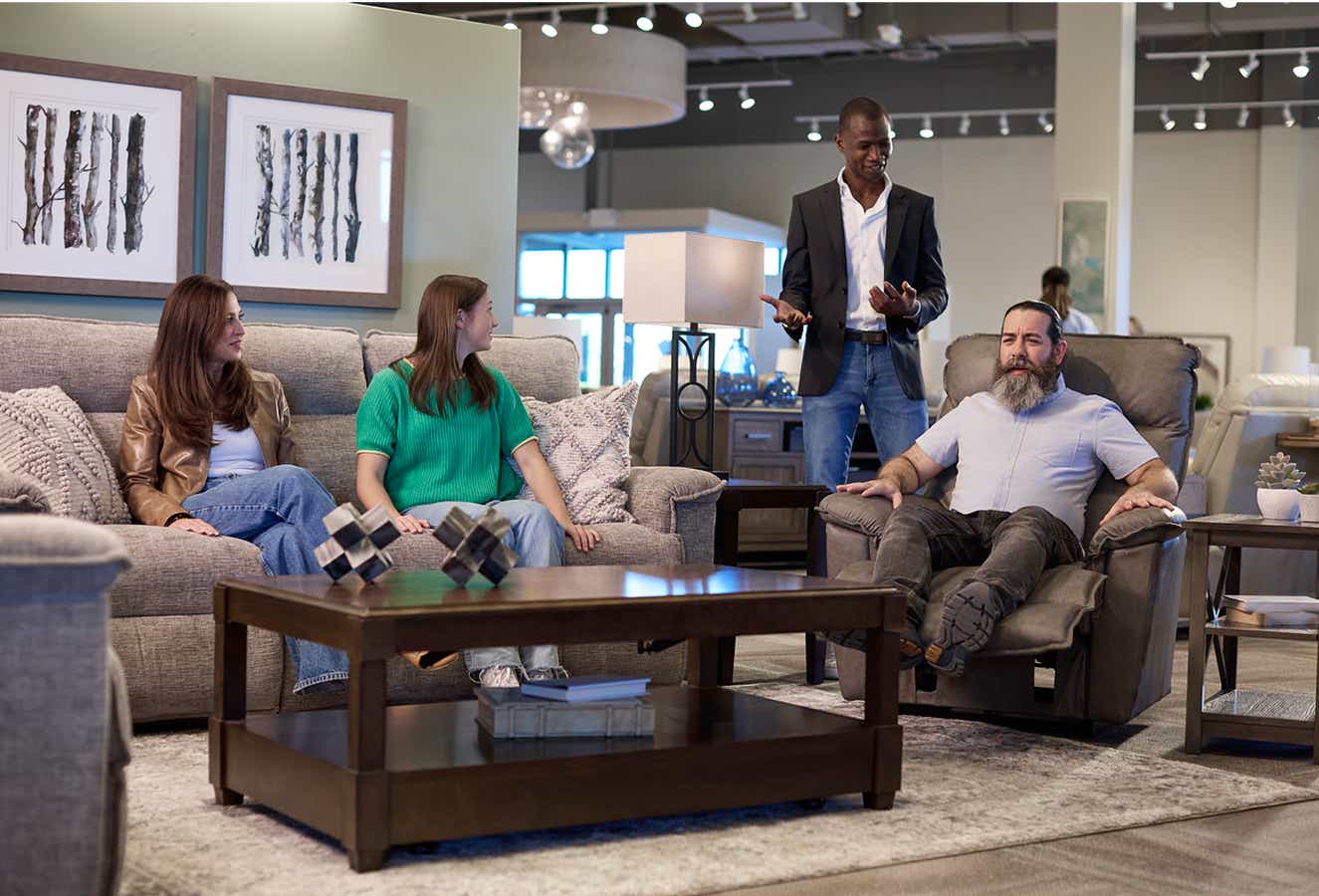 A sales associate helping a pair of customers at a La-z-boy store