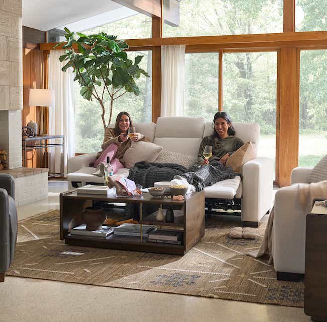 two women relaxing on a sofa